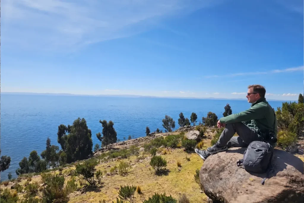 Viajero contemplando la inmensidad del Lago Titicaca desde los senderos de la Isla Taquile.