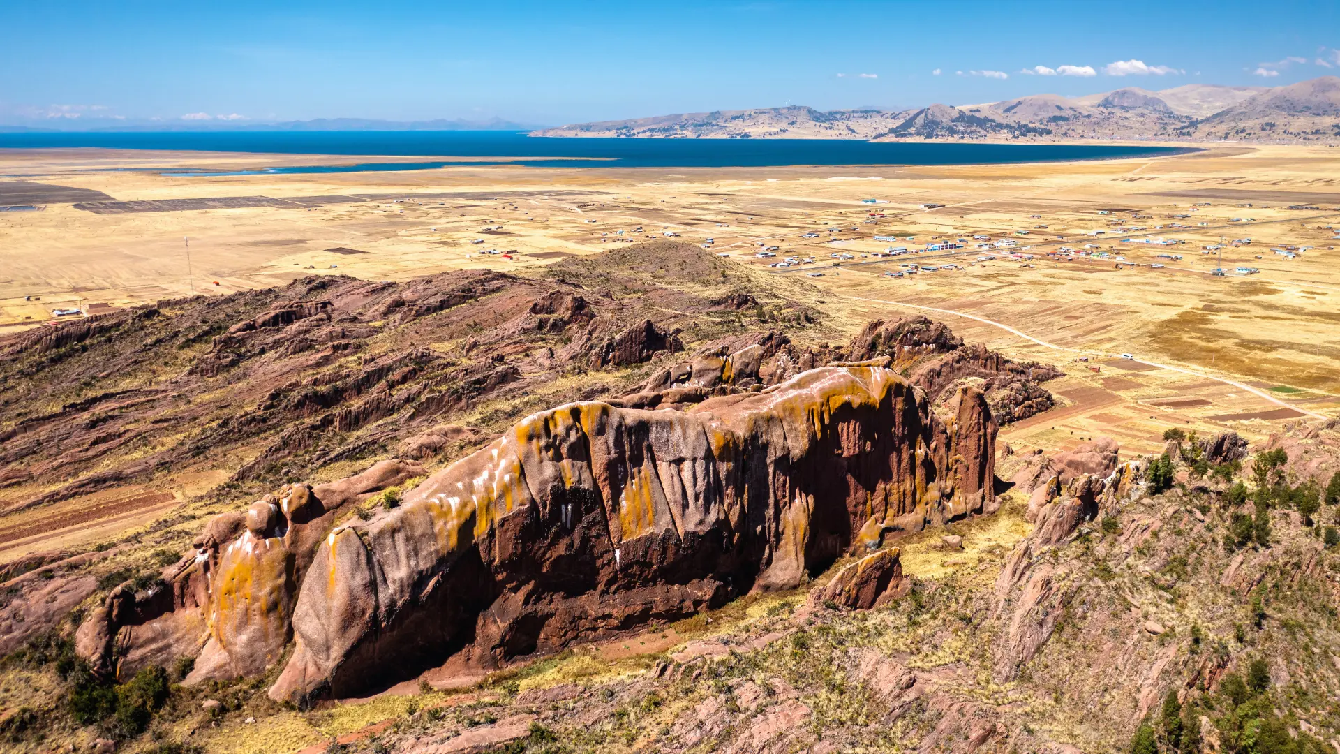 Aerial drone view of the enigmatic red rock formations perfectly aligned on the Hayu Marca plains in Puno.
